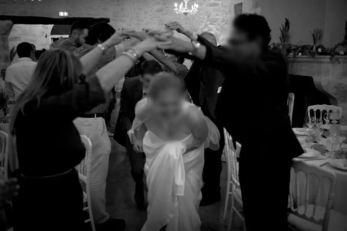 Mariée passant sous une haie d’honneur formée par les invités à l’entrée en salle