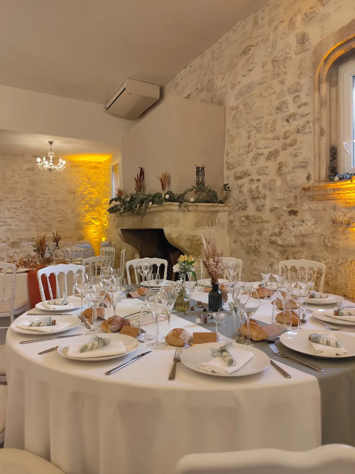 Table de mariage dressée pour le repas dans une salle en pierres apparentes