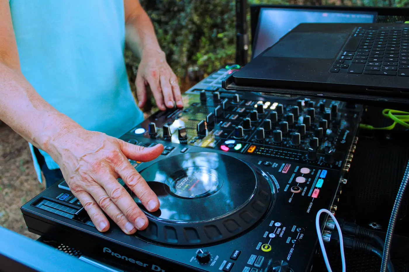 Mains de DJ Mika sur console Pioneer lors d’une prestation en extérieur