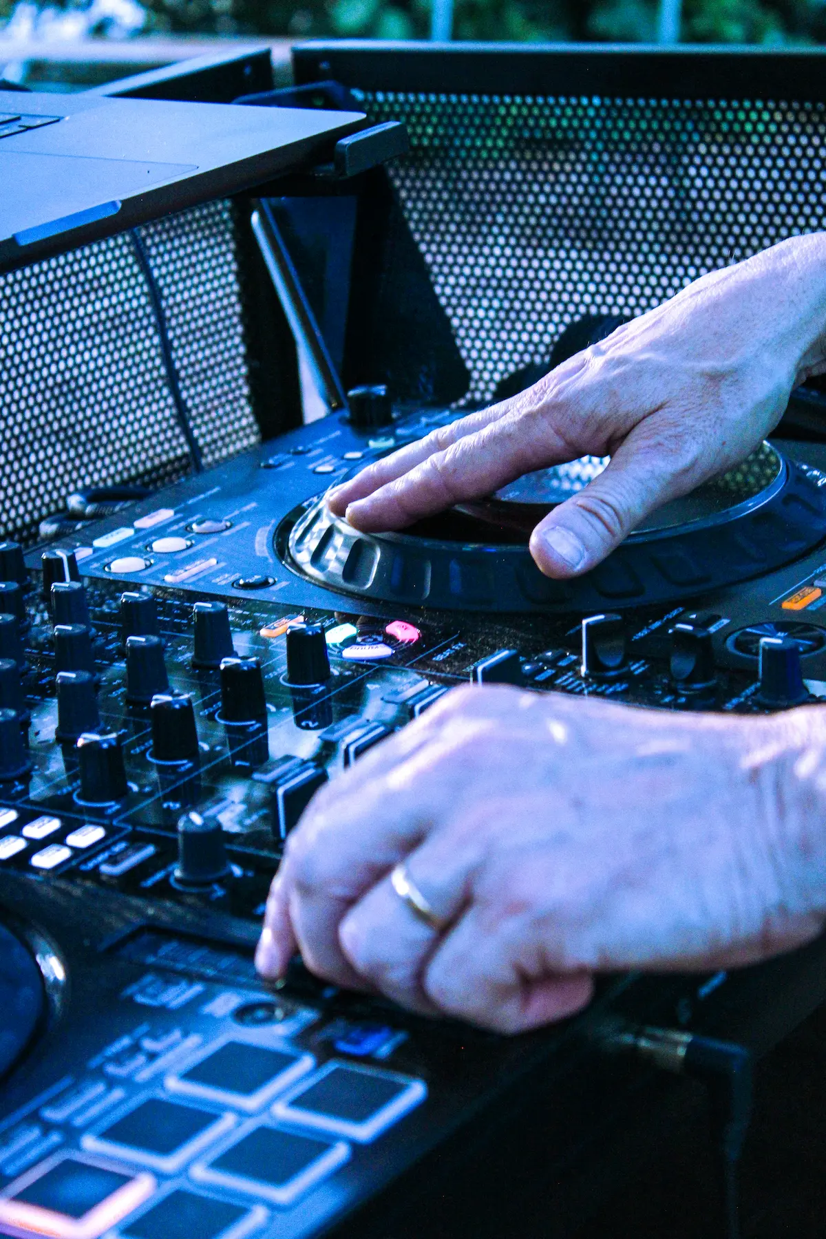 DJ Mika en plein mixage sous éclairage bleu lors d’une soirée
