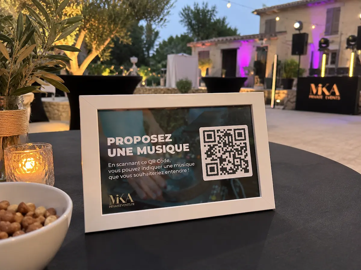 Cadre photo QR code pour proposer une musique, posé sur une table lors d’une soirée d’entreprise en extérieur dans un domaine privatisé