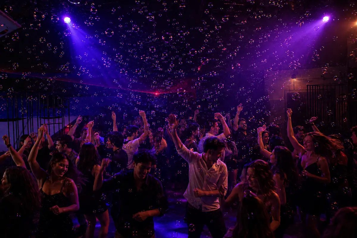 Piste de danse remplie de bulles sous éclairages violets lors d’une soirée